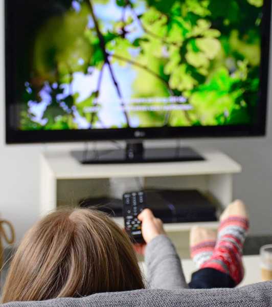 Jeune femme regardant la télévision avec des sous-titres